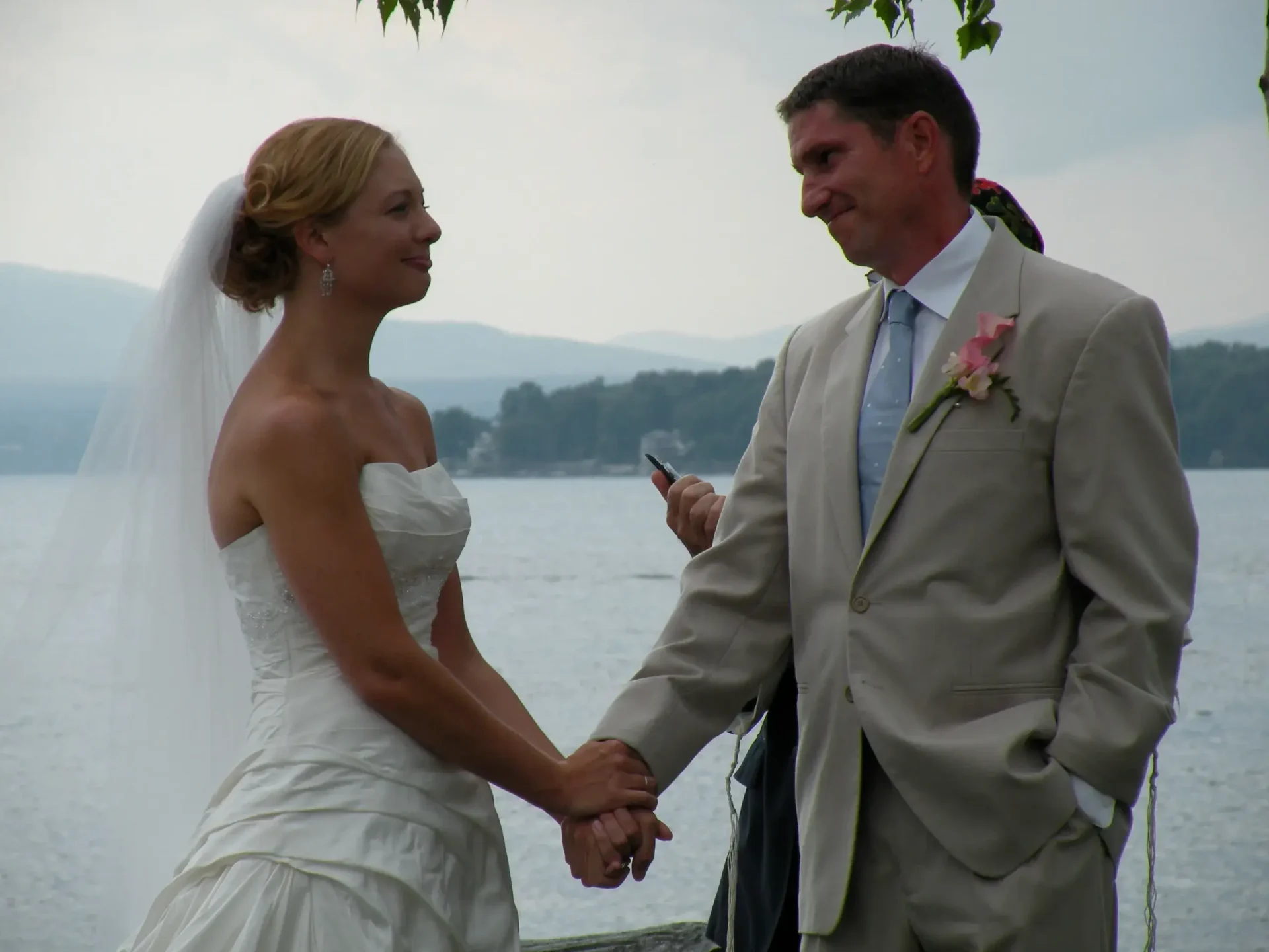 A bride and groom holding hands during their heartwarming offsite wedding ceremony.