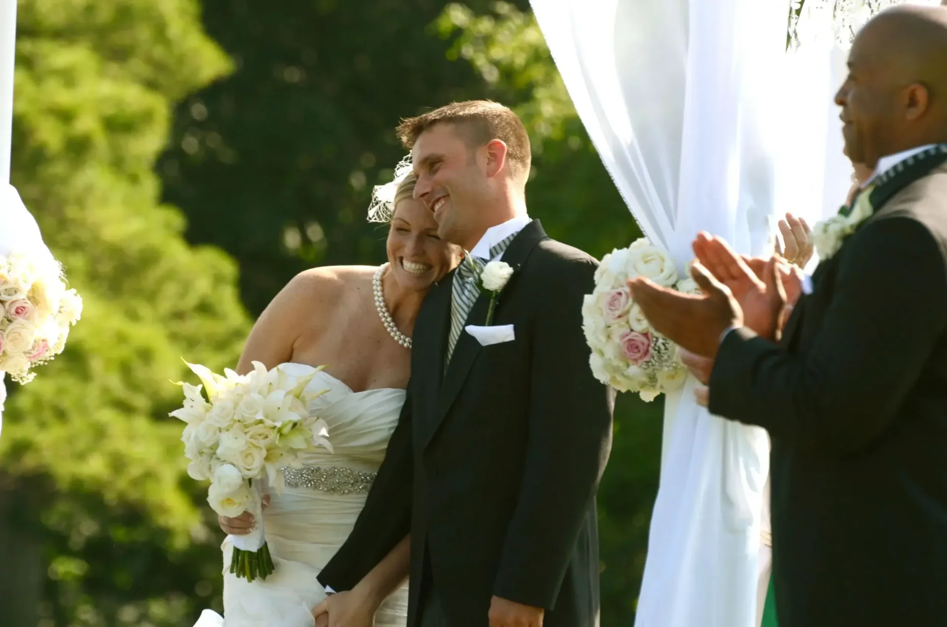 A bride and groom smiling at each other during their wedding ceremony with the assistance of Offsite Catering Services.