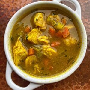 A bowl of Chicken Turmeric Lemongrass stew on a table.