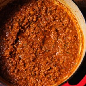 Bolognese Frozen Quart in a red pot on a wooden table.