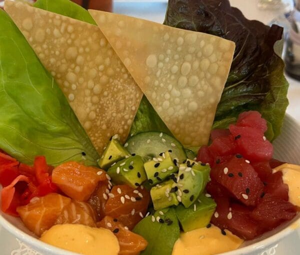 A Poke Bowl filled with a variety of sushi and vegetables.