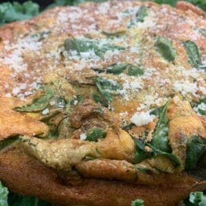 A Italian Spinach Frittata with parmesan on a plate.