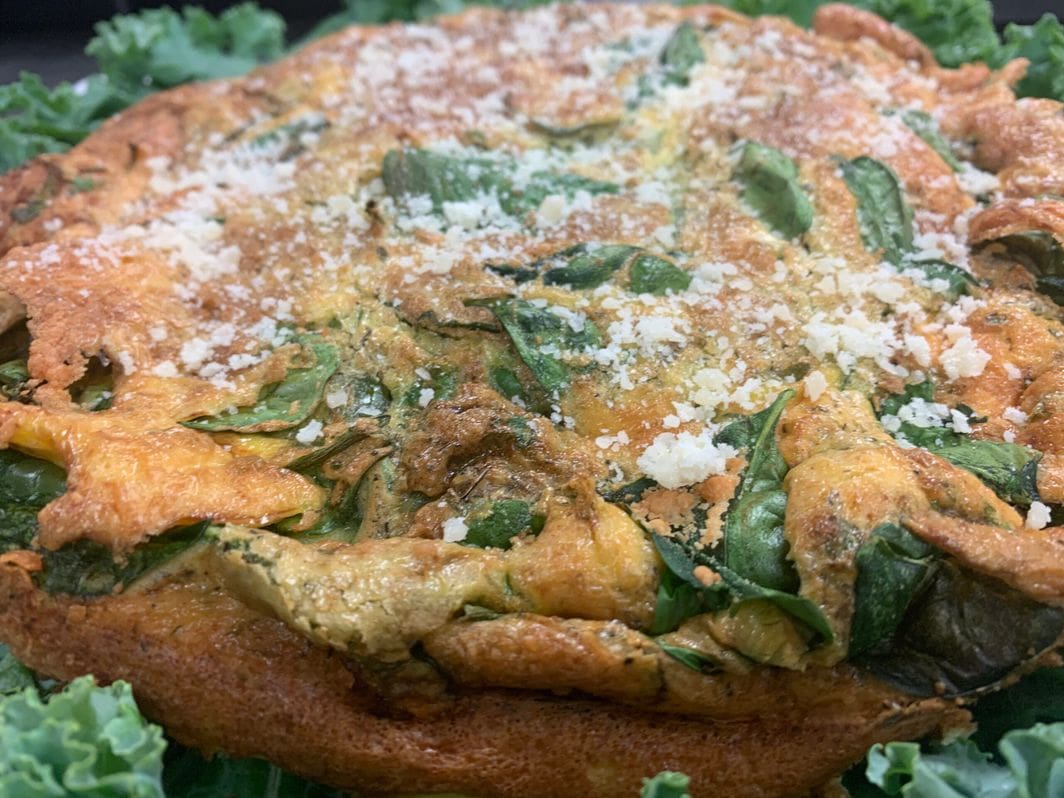 A Italian Spinach Frittata with parmesan on a plate.