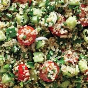 A plate of Quinoa Tabbouleh Bowls with tomatoes and cucumbers.