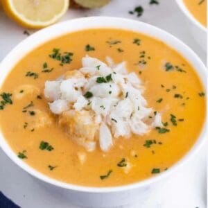 A bowl of Thai Chicken Coconut Curry 8oz soup with lemon and parsley.