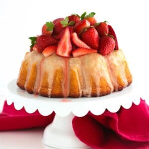 A Vanilla Bean Bundt Cake with Fresh Strawberries topped with icing.