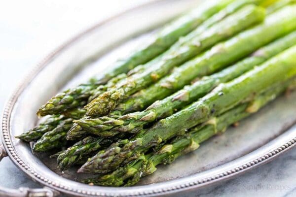 Asparagus with Herb Butter spears on a silver plate.