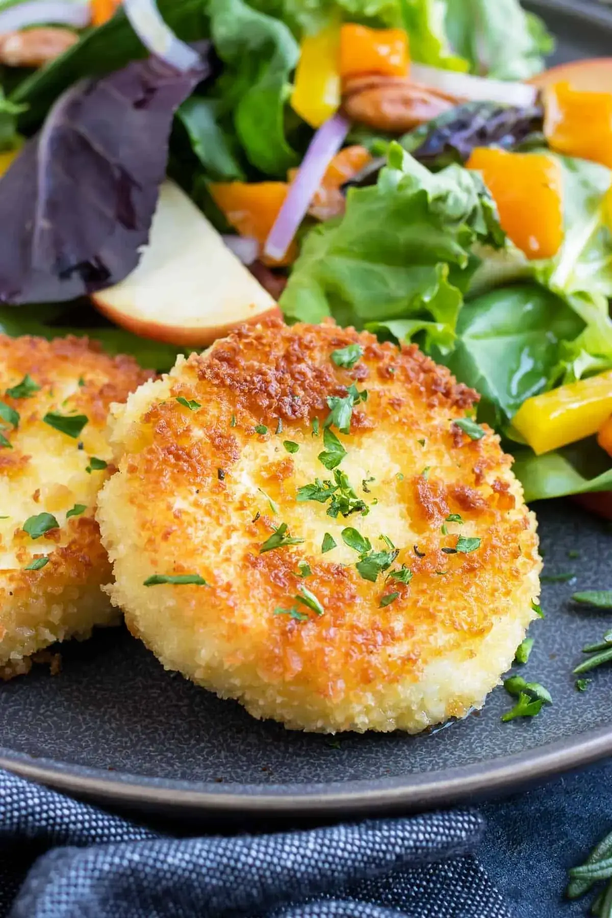 Offsite Catering Services offers a delightful combination of fried cheesecakes served with a side of salad, beautifully plated for your enjoyment.