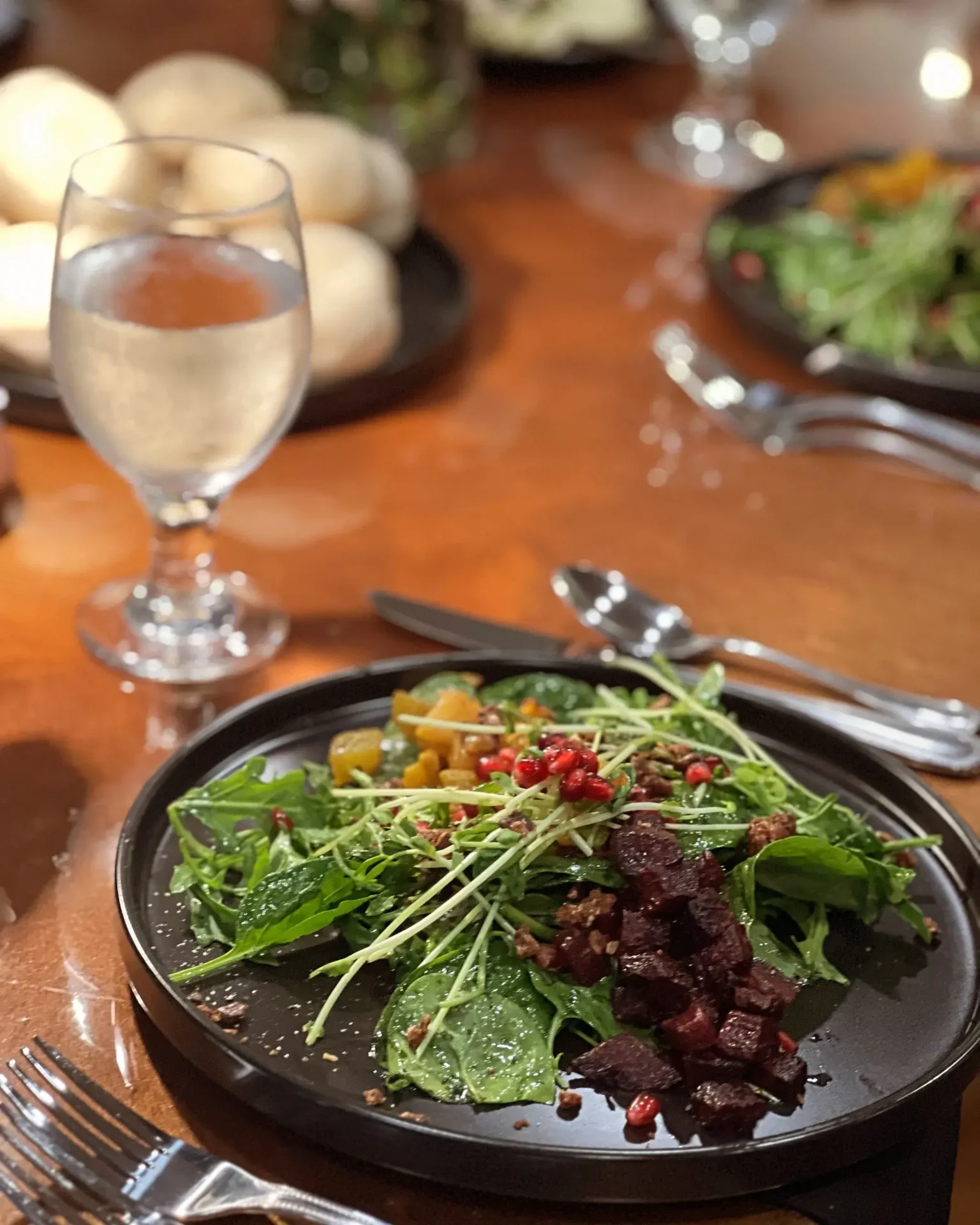 A plate of salad with pomegranate and beets on it, perfect for offsite catering services.