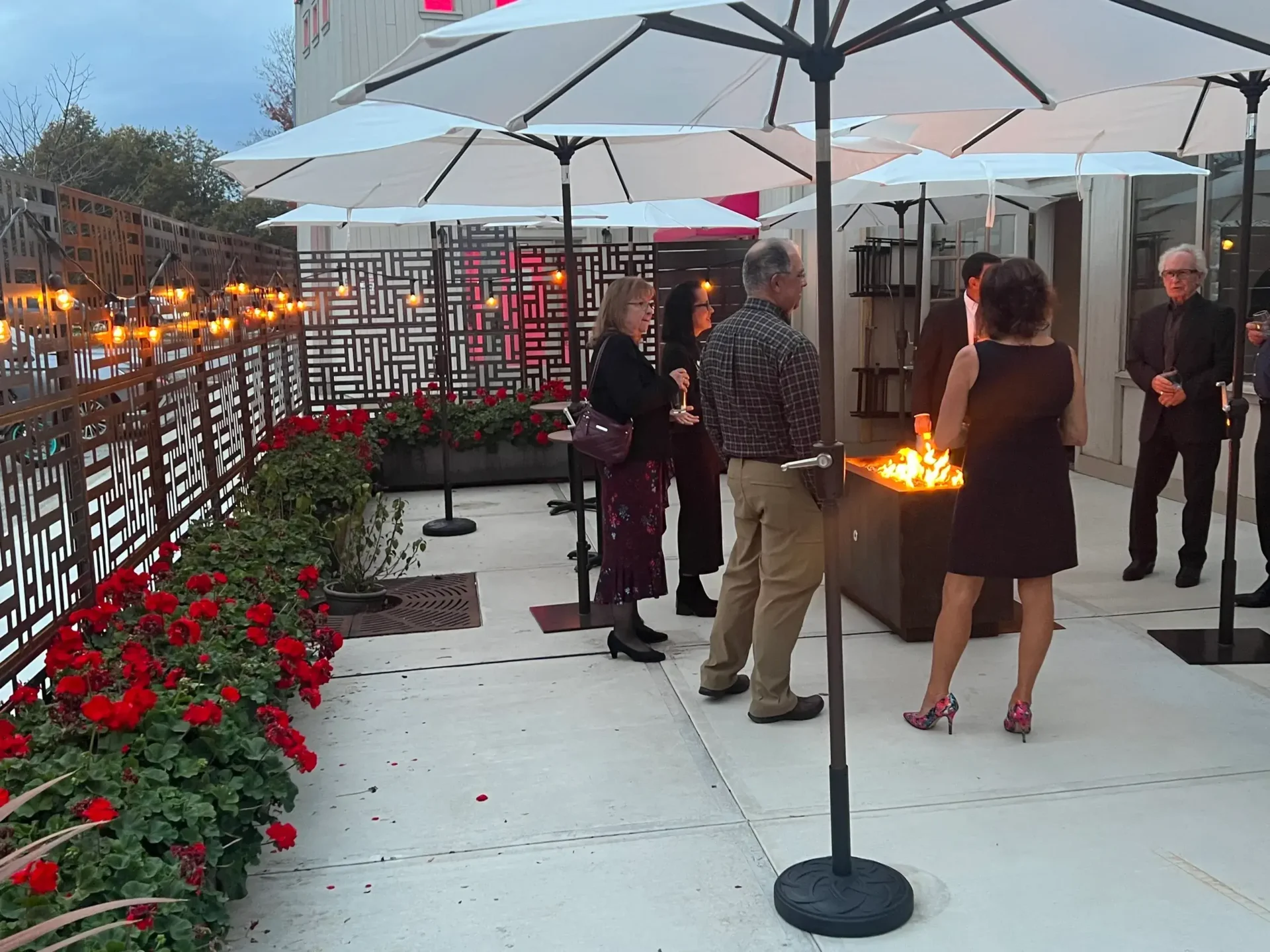 A group of people engaged in offsite catering services, standing around a fire pit.